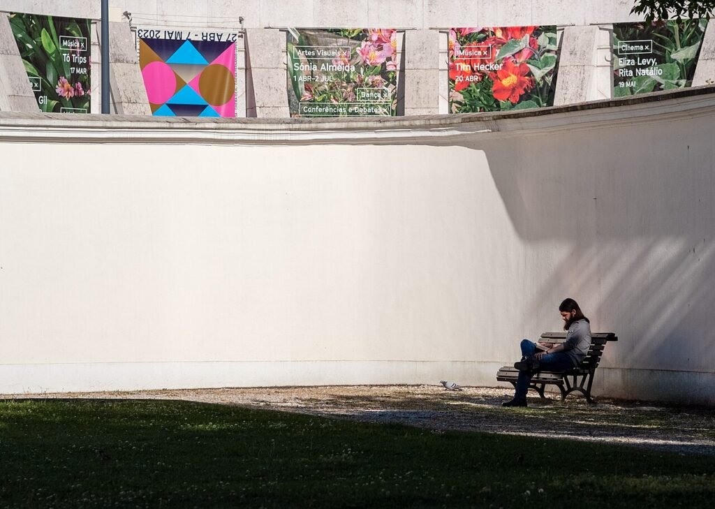 Man sitting on a bench reading a book, Palácio das Galveias, Lisbon, Portugal julesvernex2