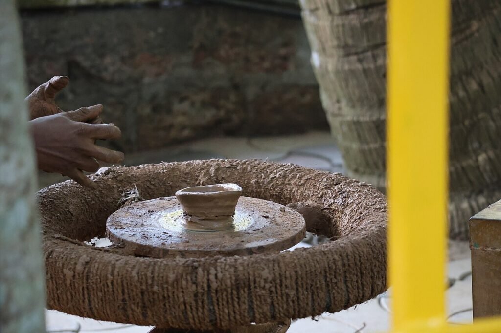 Potter shaping clay on a traditional manual potter’s wheel in India 01