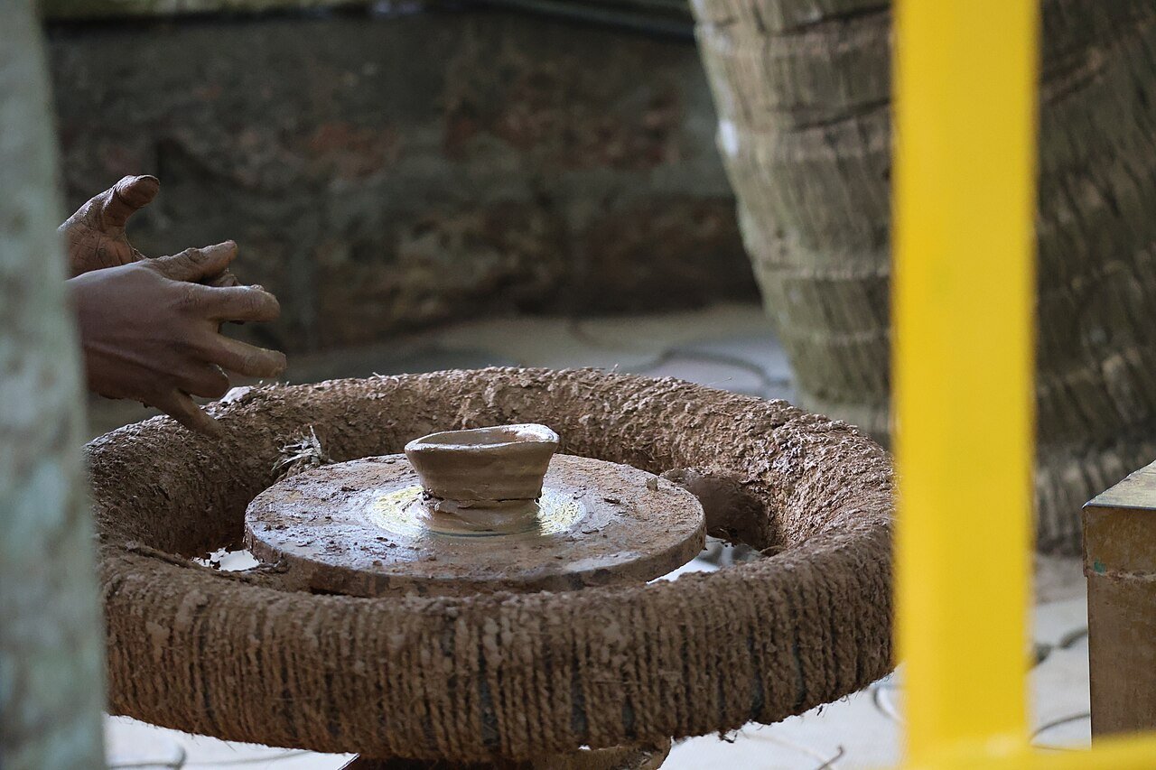 Potter shaping clay on a traditional manual potter’s wheel in India 01