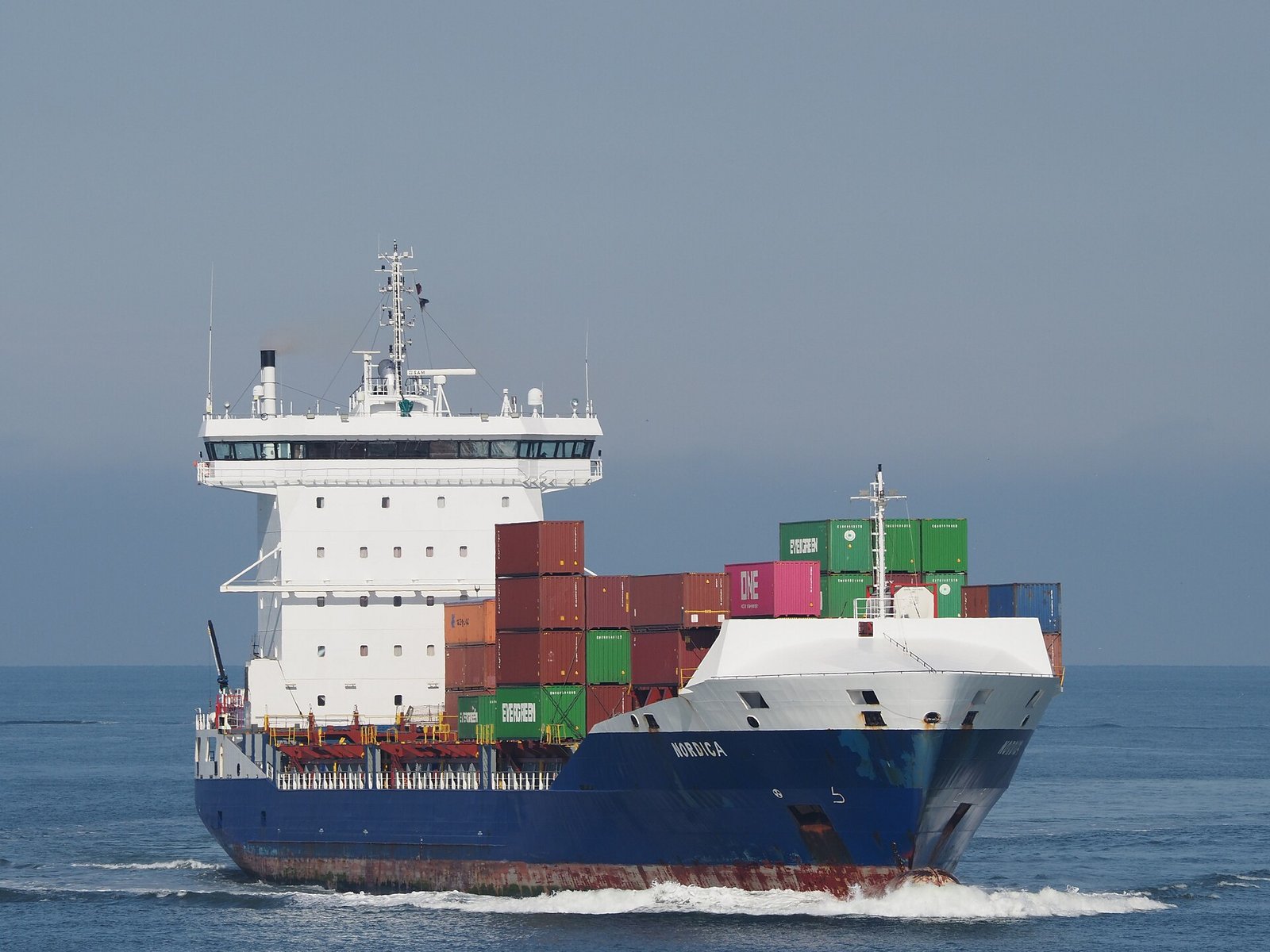 A container ship approaching the Port of Rotterdam, carrying the trade through which China clean tech exports avoid CO2 abroad