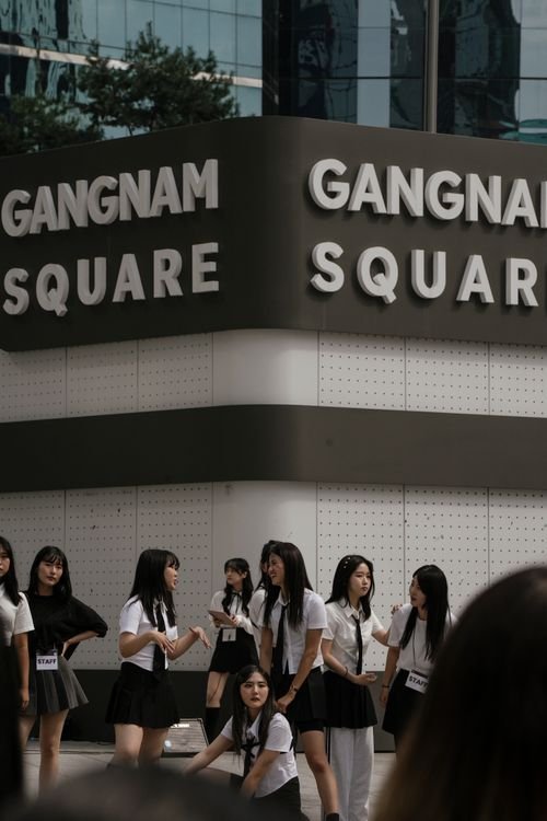 Schoolgirls in uniform in front of the Gangnam Square sign in Seoul