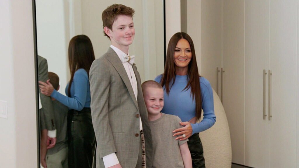 Lisa Barlow seated with her two sons in a family scene