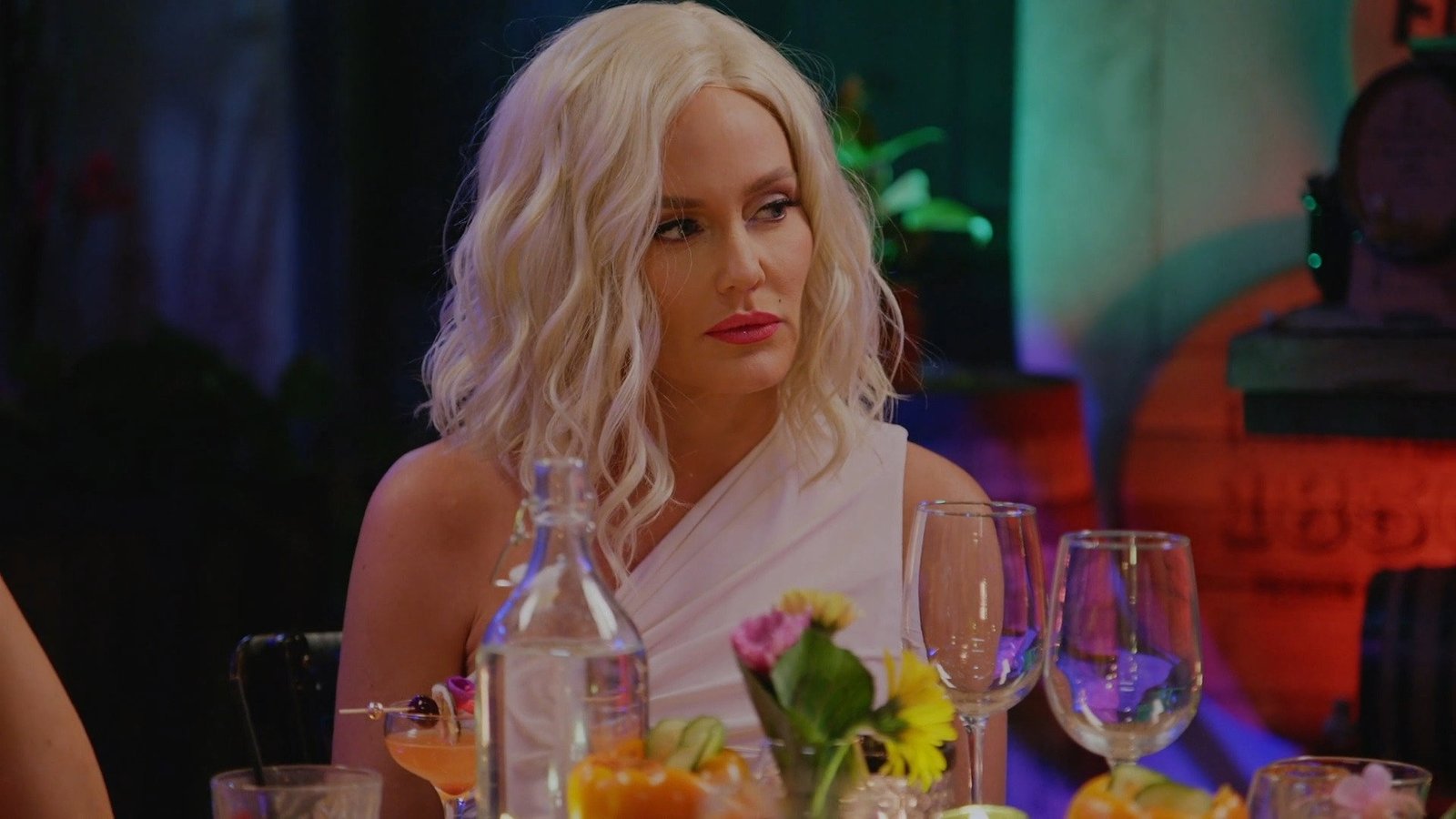 Heather Gay in a platinum wig at the Marilyn Monroe dinner in San Diego, listening intently