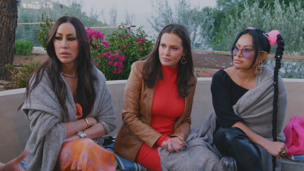 Angie Katsanevas, Meredith Marks and Jen Shah seated outdoors in San Diego, wrapped in blankets