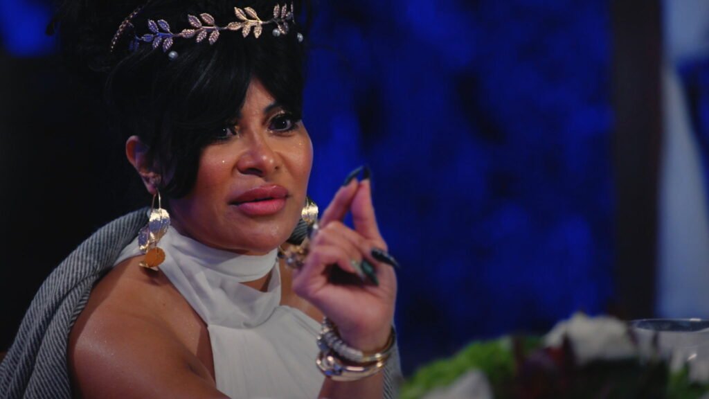 Jen Shah in a white dress and laurel headpiece at the Greek goddess dinner, making a point