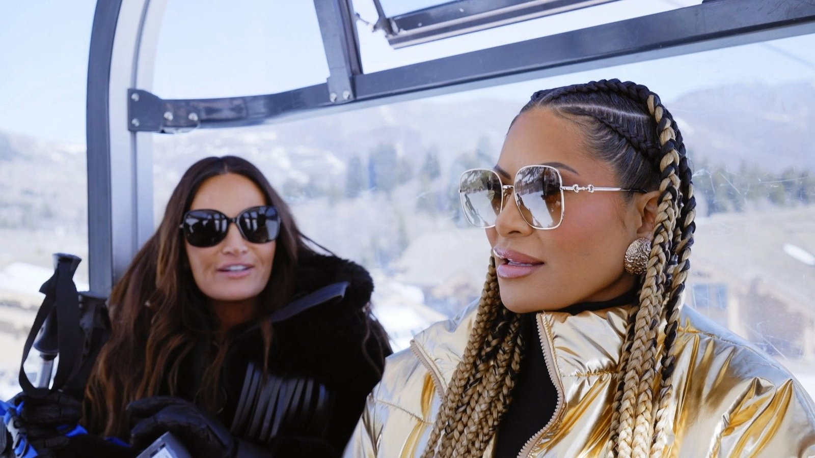 Jen Shah in a gold puffer jacket and braids beside Lisa Barlow in a ski gondola