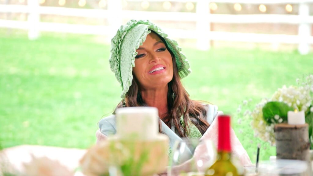 Lisa Barlow in a green pioneer bonnet at Heather Gay's Pioneer Day lunch in RHOSLC Season 4, Episode 11.
