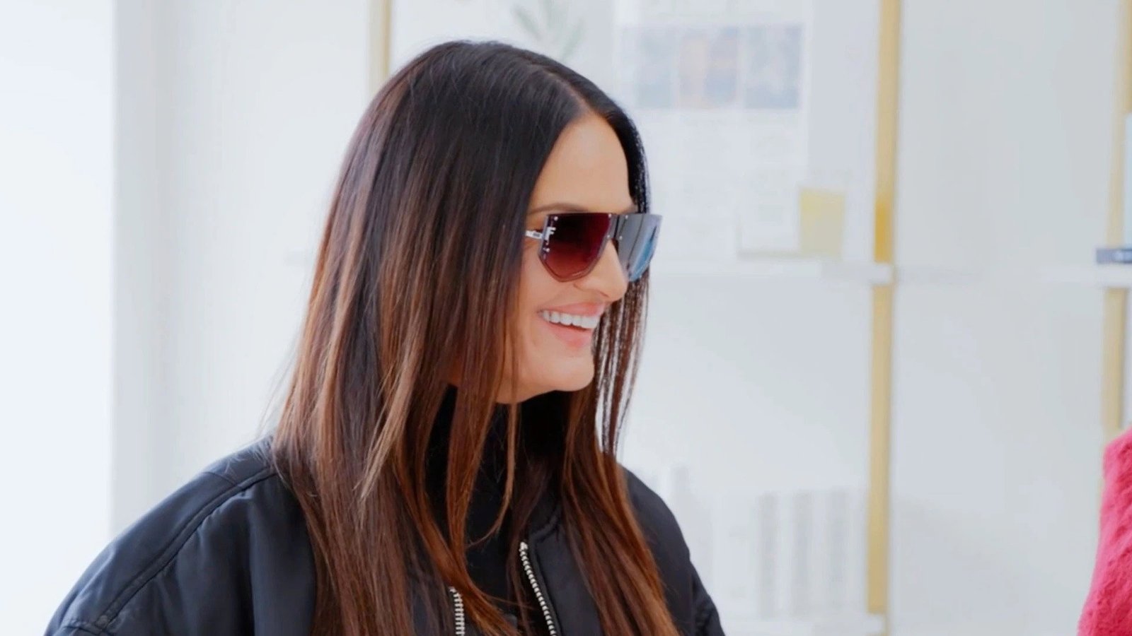 Lisa Barlow in oversized sunglasses and a black jacket, smiling