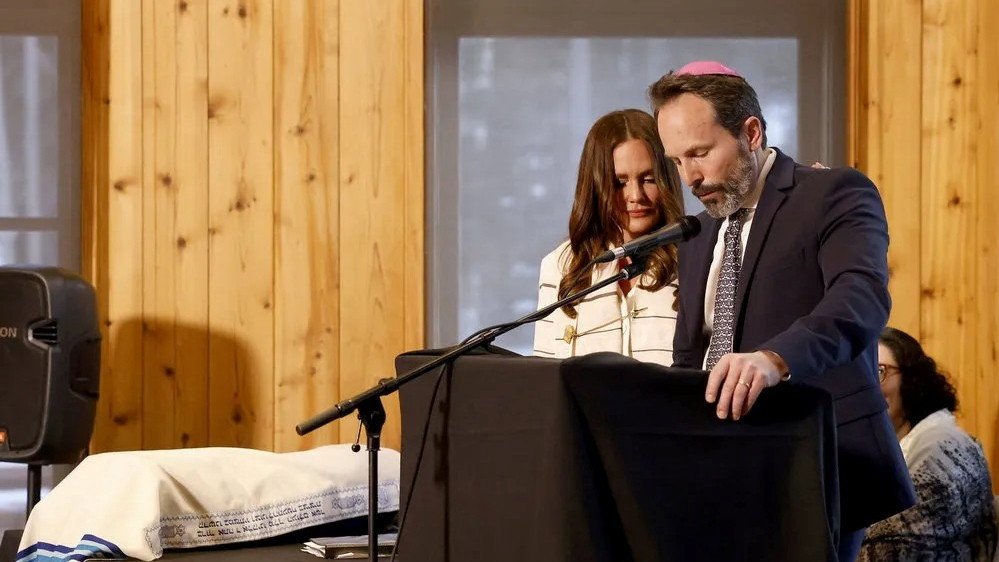 Seth Marks speaking at the bat mitzvah ceremony, with Meredith Marks beside him