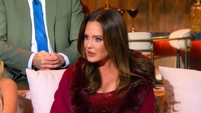 Meredith Marks seated on the reunion couch in a burgundy outfit