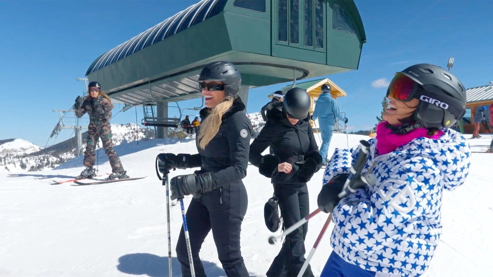 Two of the women in ski gear on the slopes below the lift